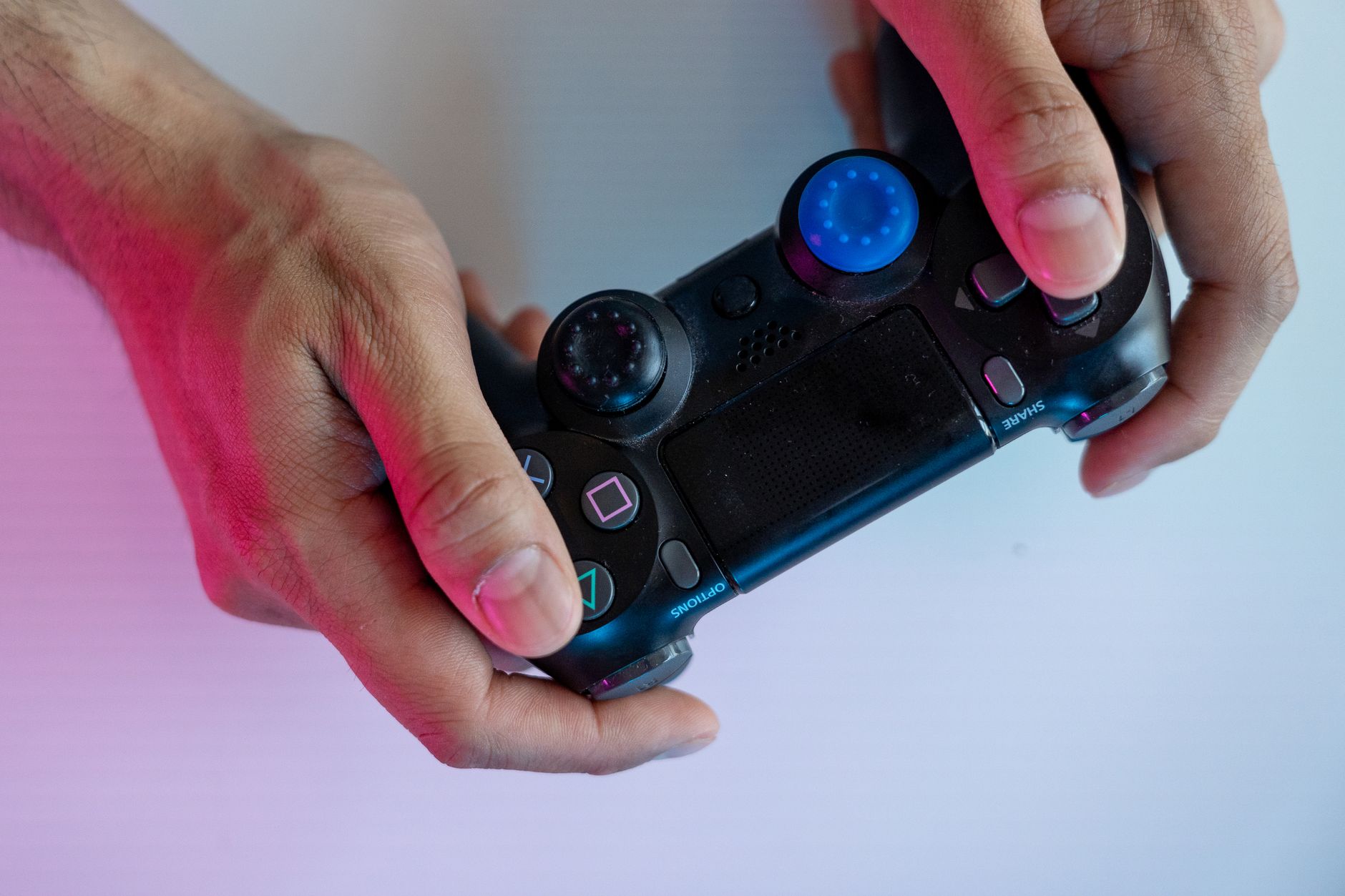 Närbild på en person som spelar konsolspel med en modern spelkontroll
